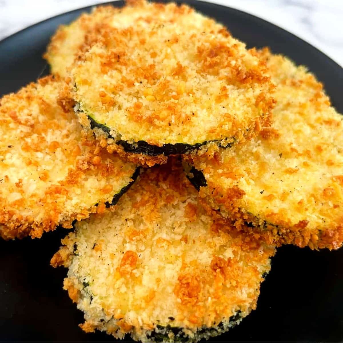 air fryer zucchini stacked on a plate