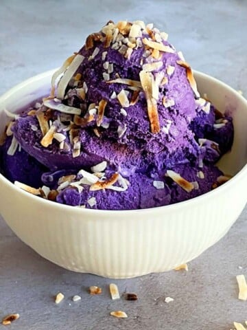 ube ice cream in a bowl with toasted coconut on top