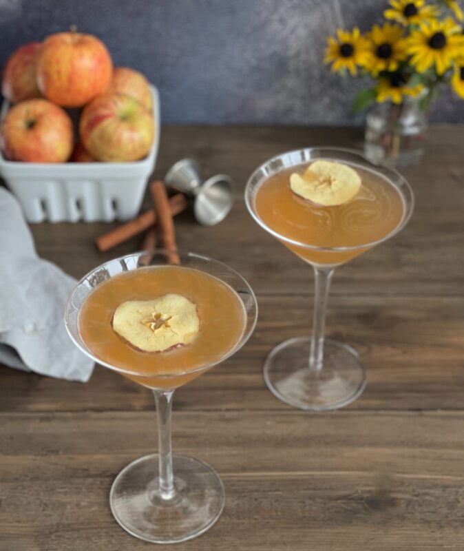 apple cider martinis with dehydrated apples floating on top.