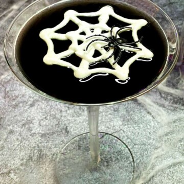 black martini with a meringue web and a toy spider
