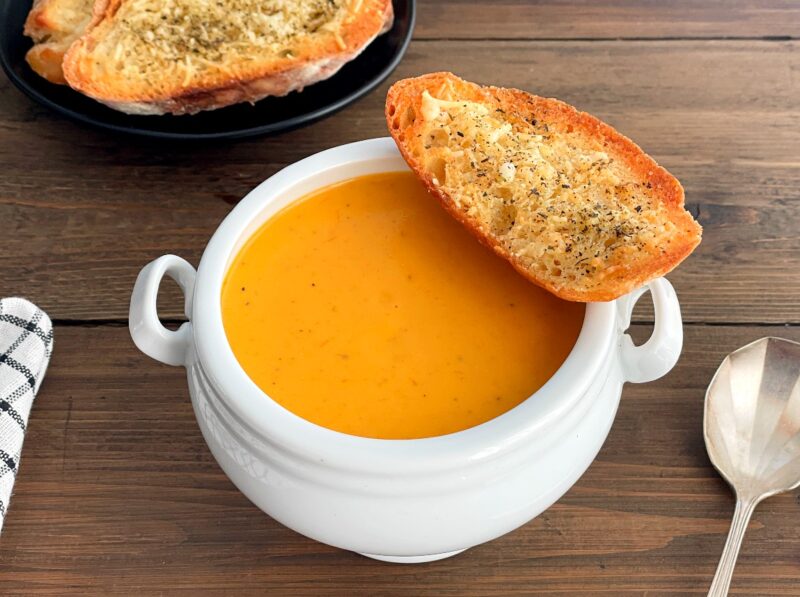 tomato soup in a bowl with garlic bread