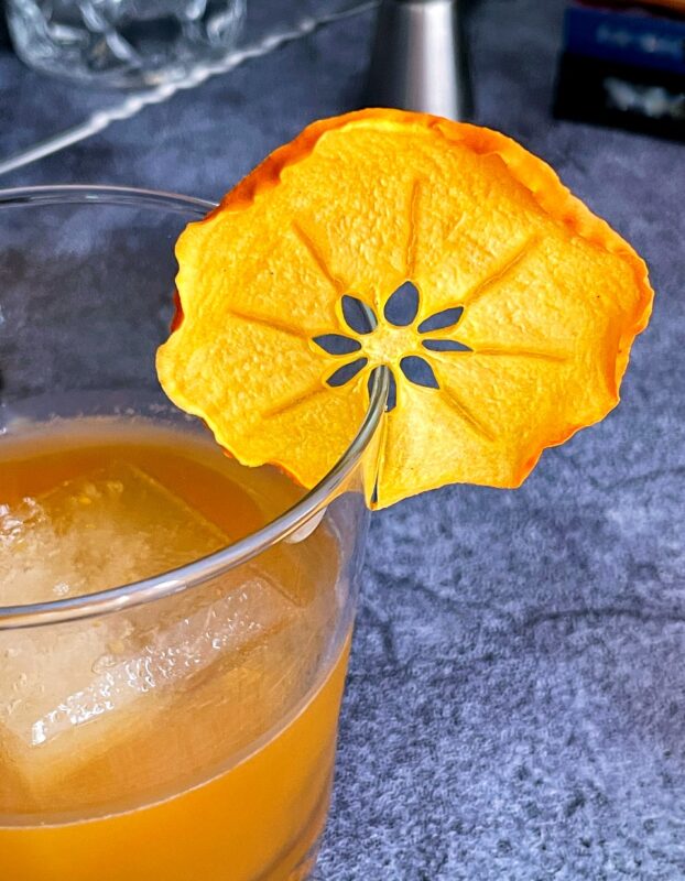 dried persimmon wheel on a bourbon persimmon cocktail