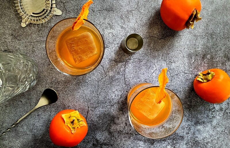 persimmon old fashioneds and Hachiya persimmons on a table