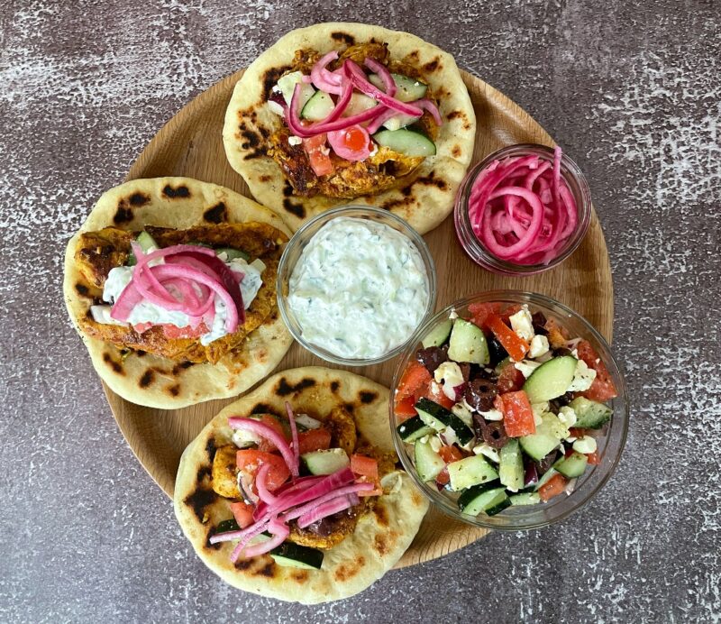 3 chicken shawarma wraps with tzatziki sauce and pickled onions.