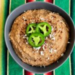 instant pot refried beans in a bowl with jalapenos on top