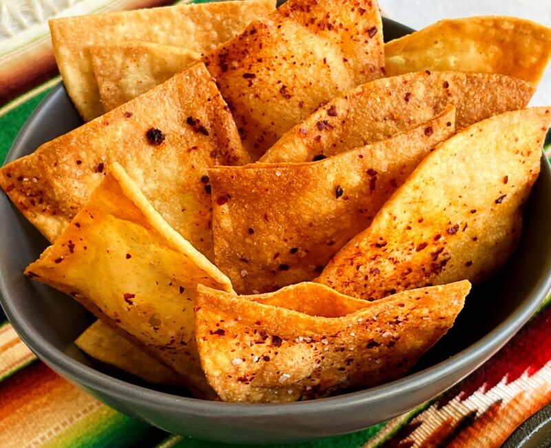 a bowl of homemade fried tortilla chips with chile powder