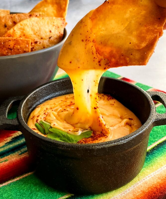 a chip dipped in queso fundido with tequila