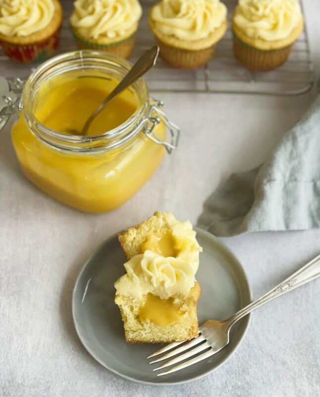 passion fruit cupcake with passion fruit curd inside and a jar of passion fruit curd