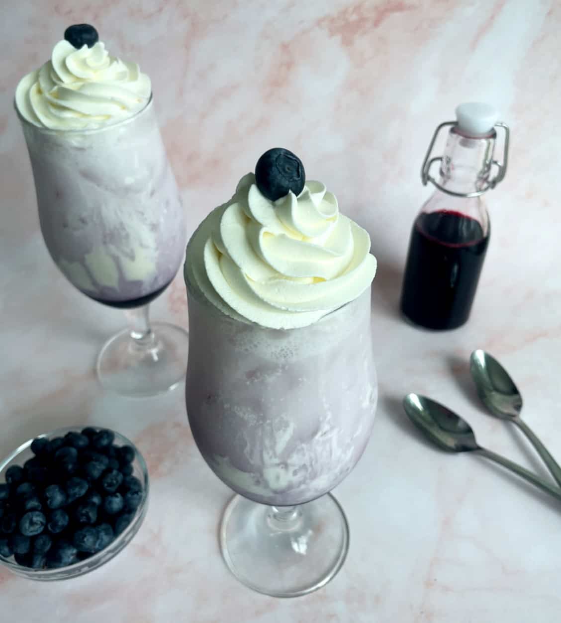 blueberry italian sodas with whipped cream swirrled on top.