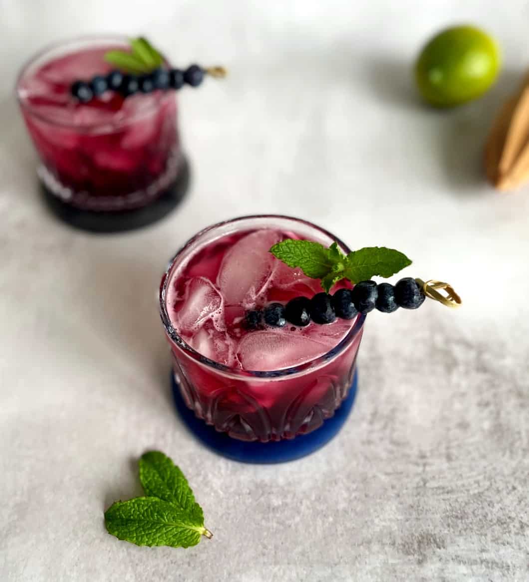 gin and tonic with blueberry syrup.
