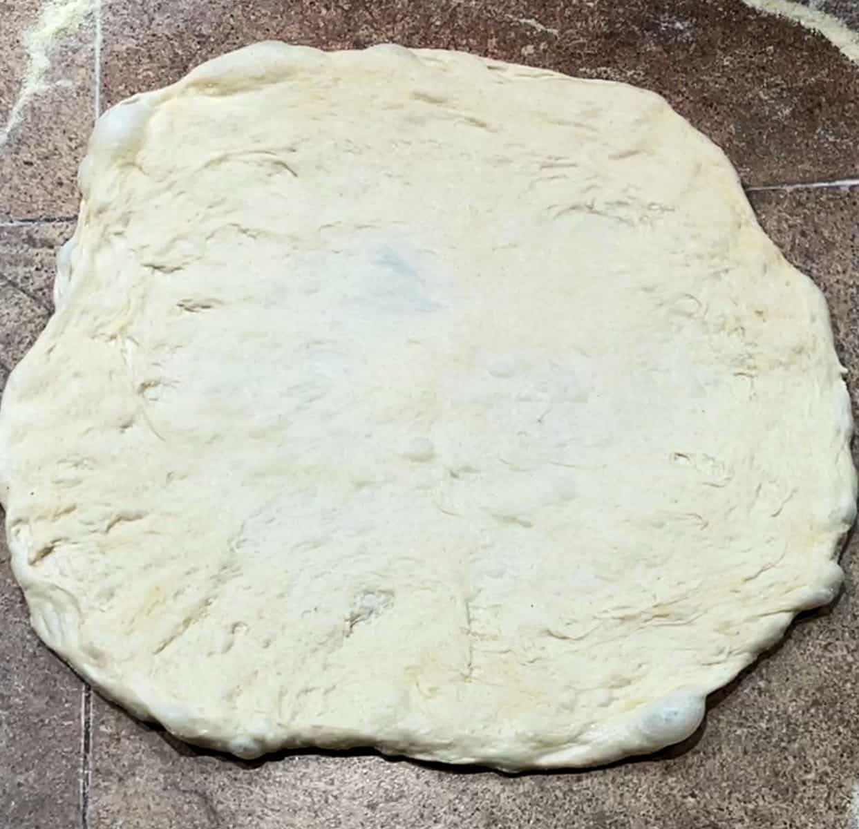 poolish pizza dough rolled out.