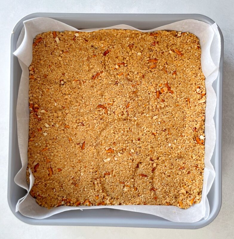 graham cracker and pretzel crust pressed into a baking pan.