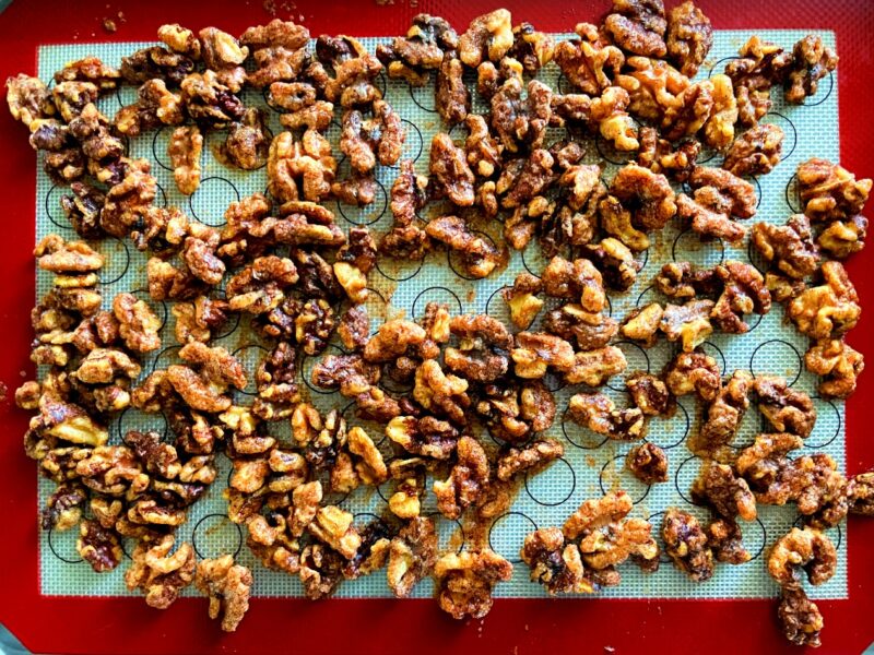 baked spiced maple walnuts on a silicone mat.