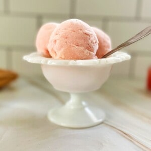 guava gelato in a bowl with a spoon