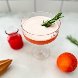blood orange gin cocktail with rosemary garnish.