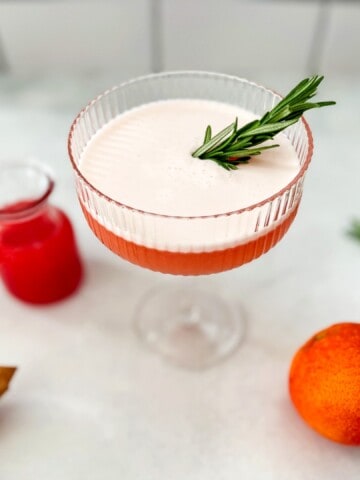 blood orange gin cocktail with rosemary garnish.