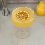 orange creamsicle drink with dehydrated orange garnish.