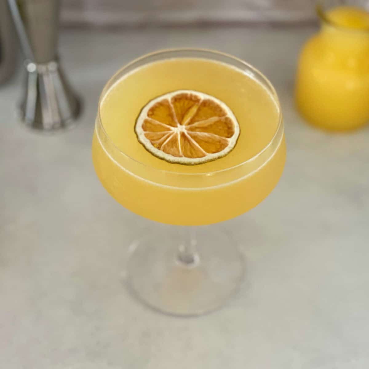orange creamsicle drink with dehydrated orange garnish.