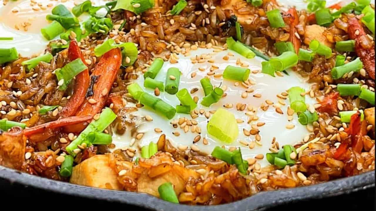 teriyaki chicken fried rice garnished with green onions and sesame seeds