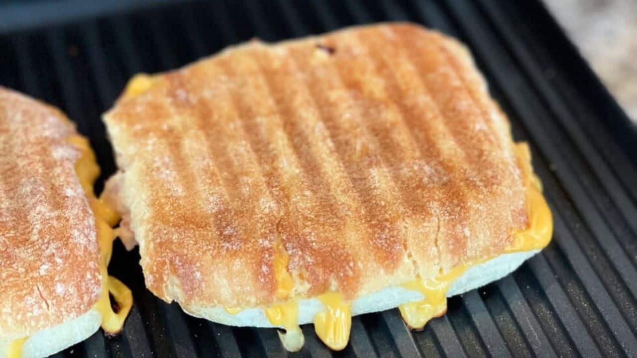 Delicious grilled canned tuna sandwich with melted cheese on a non-stick grill.