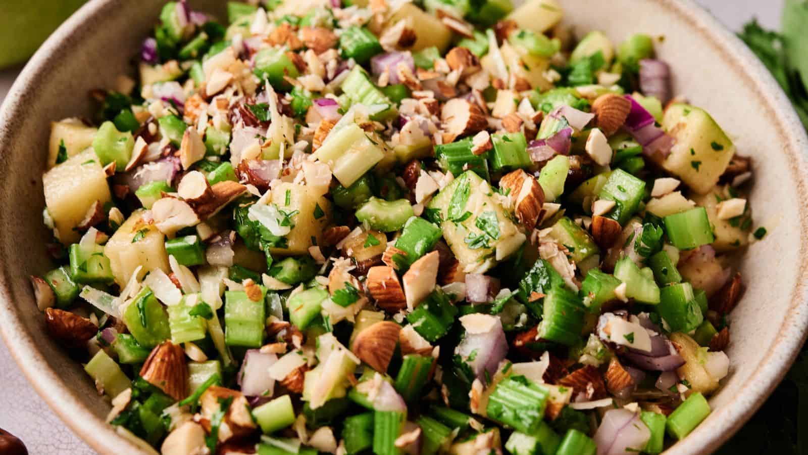 Fresh chopped green onions and nuts in a bowl, perfect for salads or garnishes.